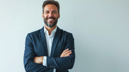 Businessman smiling with arms crossed on white backgroundの素材