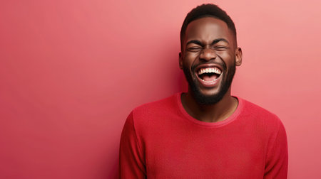 Handsome unshaven young dark-skinned male laughing out loud at funny meme he found on internetの素材
