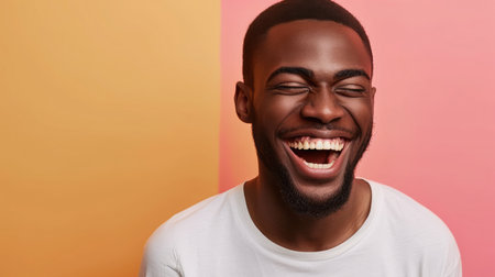 Handsome unshaven young dark-skinned male laughing out loud at funny meme he found on internetの素材