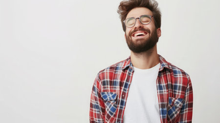 Smiling bearded young male model rejoices coming weekends, dressed casually, isolated over white background.の素材