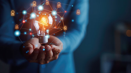 Businessman hand holding creative light bulb with industry network,analysis solution and development marketing network icons planning strategy, Modern businessの素材
