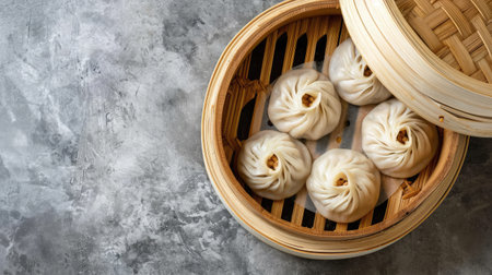 Steamed baozi dumplings stuffed with meat in a bamboo steamer. Gray background. Top viewの素材
