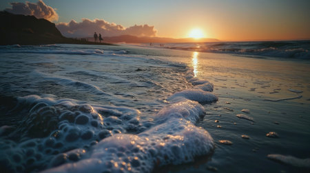 Amazing beach sunset with endless horizon and lonely figures in the distance, and incredible foamy waves.の素材