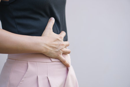 Asian woman having stomach pain from stomach disease not eating on time