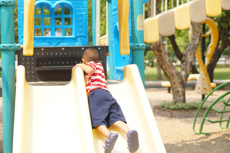 boy playing in the playground in the parkの写真素材