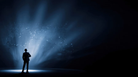Silhouette of businessman stands confidently against dark background, illuminated by beams of light that create digital world map. scene conveys sense of ambition and global perspectiveの素材