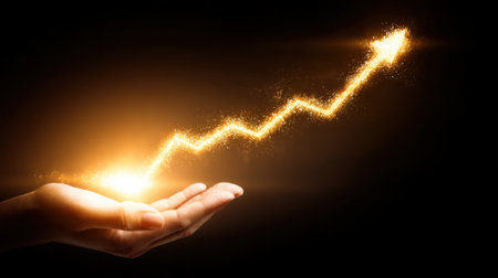 A hand holds a sparkling golden arrow, symbolizing growth and success. The dynamic upward motion captures the essence of achievement and financial progress.の素材