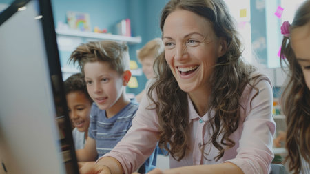 Happy mature teacher and students using desktop PC in classroomの素材
