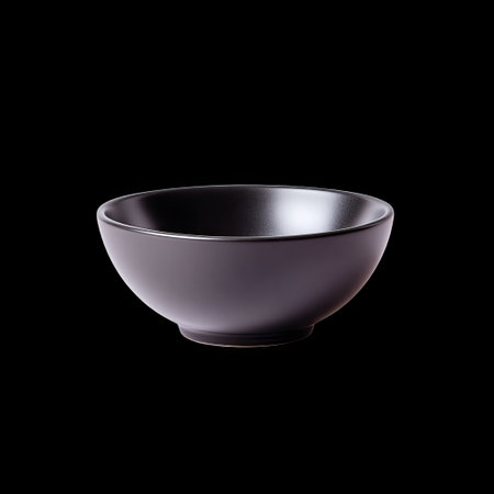 A matte black bowl with smooth finish, elegantly shaped and isolated black background, perfect for modern dining and serving. its minimalist design adds touch of sophistication to any table settingの素材