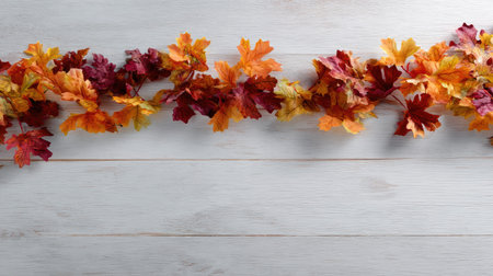 A stunning arrangement of colorful autumn leaves in vibrant hues on a rustic wooden background. Ideal for fall decor and seasonal themes, this image captures the essence of nature's beauty during harvest time.の素材