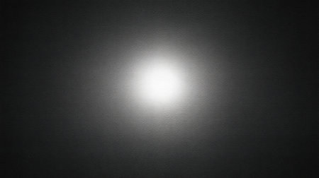 This image captures a soft glow of light emerging from a dark surface, creating an abstract, minimalistic design perfect for various background uses.の素材