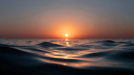 A stunning view of a vibrant sunset over calm ocean waves, capturing the tranquility and beauty of nature during dusk. This serene scene invites relaxation.の素材