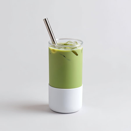 This image depicts a refreshing iced matcha beverage served in a modern glass with a metal straw, perfect for stylish summer enjoyment and wellness.の素材