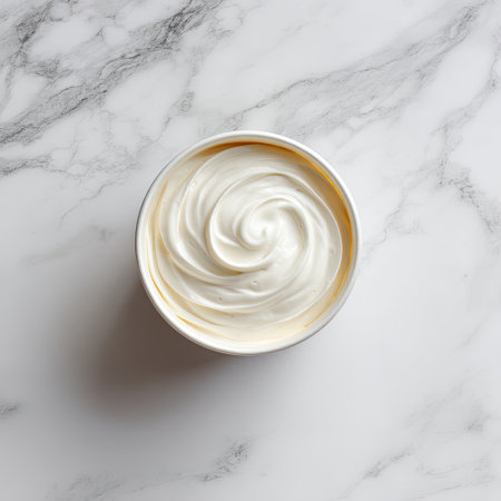 This image showcases a bowl of smooth, creamy whipped topping with a beautiful swirl, resting on a luxurious marble surface, perfect for culinary use.の素材