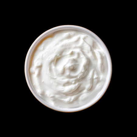 A smooth and creamy yogurt sits beautifully in a round bowl against a stark black background, showcasing its rich texture and inviting appearance.の素材