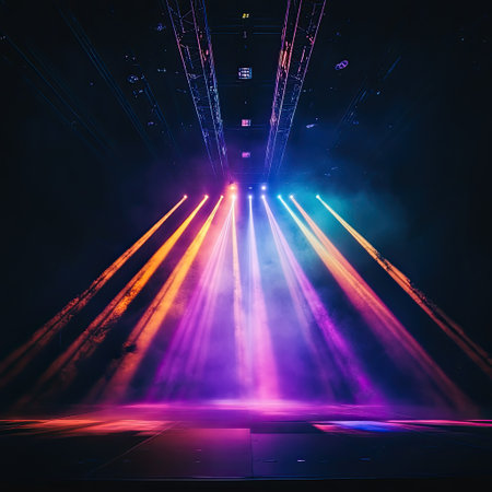Abstract beams of multicolored stage lights crossing through smoke in dark concert hallの素材