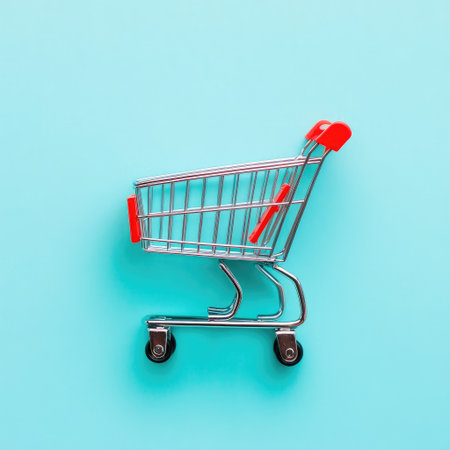Flat lay of a mini shopping cart on a pastel blue background, isolated with empty spaceの素材