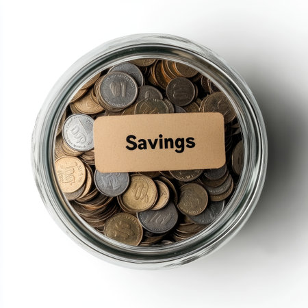 Glass jar filled with coins labeled Savings on white background, top viewの素材