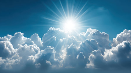 A stunning display of bright sunlight filtering through fluffy white clouds against a vibrant blue sky. This image evokes feelings of peace, tranquility, and inspiration.の素材