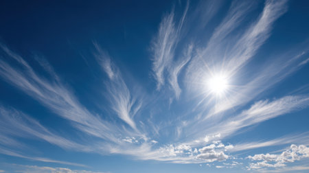 A beautiful display of wispy clouds stretches across a clear blue sky, highlighted by bright sunlight. This captivating scene embodies serenity and natural beauty in the sky.の素材