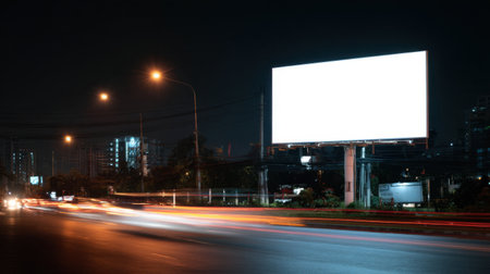 A blank billboard at night against a backdrop of city lights creates an intriguing scene showcasing urban energy and advertising possibilities in a tranquil setting.の素材