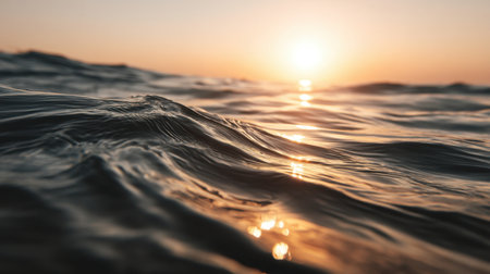 Experience the calming beauty of the ocean at sunset, with gentle waves illuminated by warm golden light. This serene scene captures nature's peaceful ambiance and tranquility.の素材