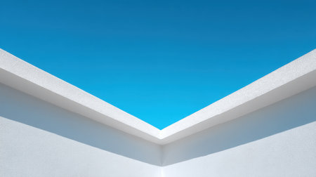 This image showcases a minimalist architectural feature with a crisp white wall meeting a clear blue sky, creating a serene and modern aesthetic perfect for various applications.の素材