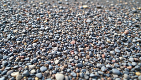 This image showcases a detailed close-up of colorful pebbles and gravel on a beach, revealing unique textures and patterns formed by nature, creating a serene atmosphere.の素材