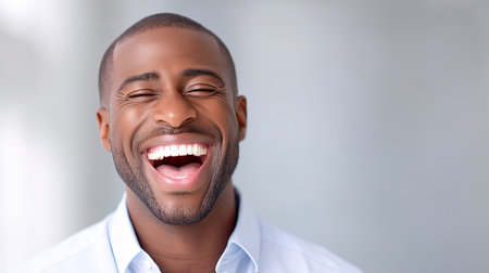 A closeup of man bursting with laughter, showcasing joy and happiness in bright setting. his genuine smile radiates positivity and warmth, creating uplifting atmosphereの素材