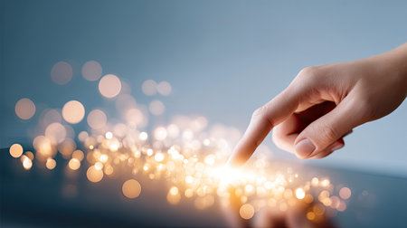 A delicate hand reaching out to touch shimmering lights, creating a magical atmosphere. The soft blue background enhances the effect, ideal for artistic and inspirational themes.の素材