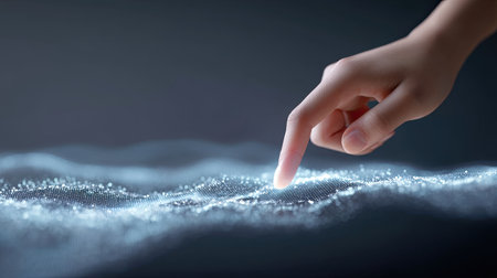A captivating image of a human finger gently tapping on a shimmering digital surface, surrounded by soft light and floating particles, evoking a sense of futuristic interaction.の素材