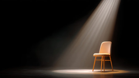 A beautifully lit wooden chair stands alone in a spotlight against a dark backdrop, creating a minimalistic and elegant scene perfect for artistic photography.の素材