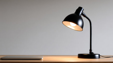 A modern desk lamp illuminating workspace, symbolizing dedication and focus. sleek design enhances productivity in minimalist environment, creating warm and inviting atmosphereの素材