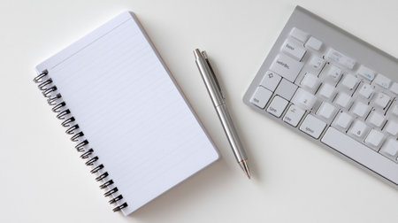 A clean organized workspace with closed notebook, pen, and keyboard, creating serene atmosphere for productivity and creativityの素材