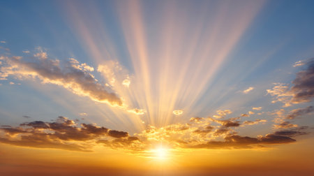 A radiant golden sky at twilight with dramatic sunbeams illuminating horizon, creating breathtaking view that evokes sense of peace and wonderの素材