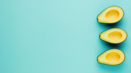 Freshly sliced avocados arranged on a soft blue background, showcasing their vibrant color and creamy texture. Perfect for healthy lifestyle themes.の素材