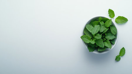 A vibrant bowl of fresh mint leaves set against a light background, perfect for culinary uses, garnishes, and enhancing dishes with natural aromas.の素材