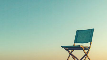 An empty chair sits alone under a clear blue sky at sunset, evoking a sense of solitude and tranquility in a serene outdoor environment. Perfect for conveying peace.の素材
