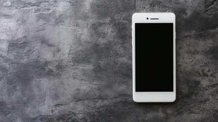 A modern smartphone displayed on a grungy gray surface, perfect for showcasing digital applications or marketing materials. Ideal for tech-related themes.の素材