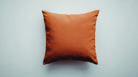 A beautiful orange pillow placed against a light background, ideal for home decor. This cozy cushion adds warmth and style to any living space or interior design project.の素材