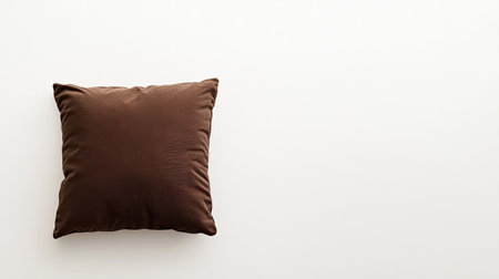 A soft brown cushion rests elegantly on a serene white background, showcasing its plush texture, ideal for home decor and elegant interior design ideas.の素材