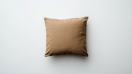 A soft brown cushion placed on a minimalist background, ideal for enhancing cozy interiors and adding a touch of style to any living space.の素材