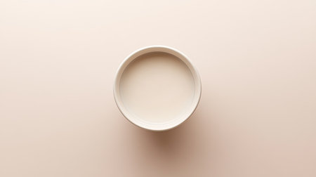 A simple round white bowl is centered on a minimalist beige background, ideal for showcasing food, enhancing table settings, or serving modern design aesthetics.の素材