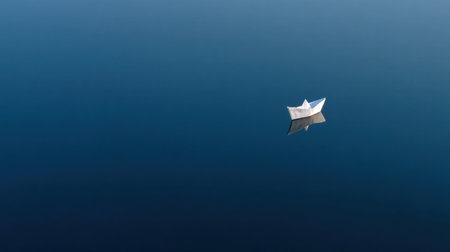 A peaceful and minimalist scene featuring a small paper boat floating on calm blue water, capturing reflections and evoking feelings of tranquility and serenity.の素材
