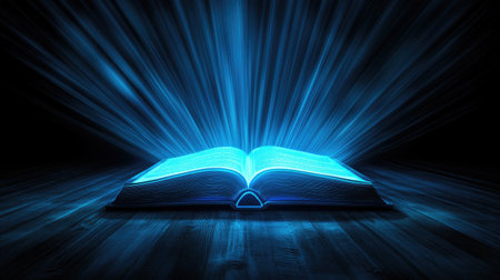 An artistic representation of an open book radiating blue light beams in a dark setting. This captivating image conveys themes of knowledge, imagination, and inspiration.の素材