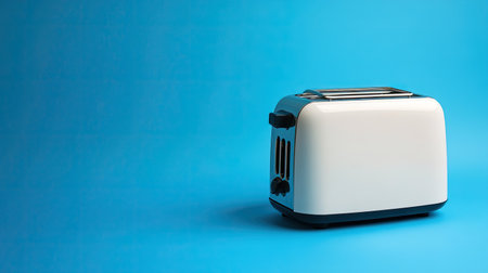 A sleek classic white toaster positioned against a bright blue background. This image captures the essence of modern kitchen appliances, ideal for showcasing breakfast preparation and culinary convenience.の素材