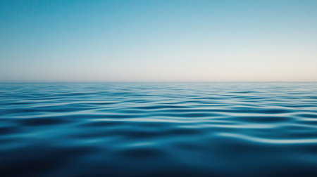A captivating view of a calm ocean with gentle waves under a clear blue sky. The scene evokes tranquility and peace, making it ideal for relaxation themes.の素材
