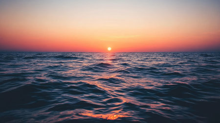 Breathtaking view of a tranquil sunset over calm ocean waves, capturing the serene atmosphere as daylight fades into night. Perfect for nature lovers.の素材