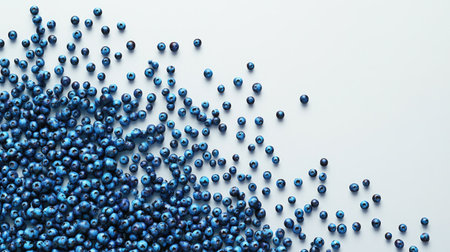 A visually pleasing arrangement of fresh blueberries scattered across a soft blue background. This image captures the vibrant colors and healthy appeal of the fruit, perfect for culinary and dietary themes.の素材