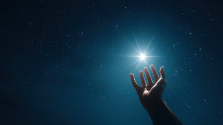 A solitary hand extended towards a brilliant star in the vast night sky, symbolizing hope and dreams. The serene atmosphere invites reflection and inspiration.の素材